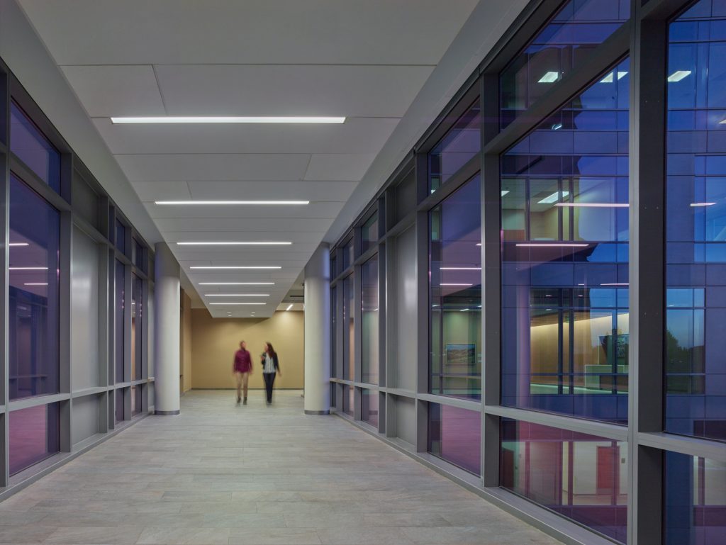 a couple of people walking down a hallway