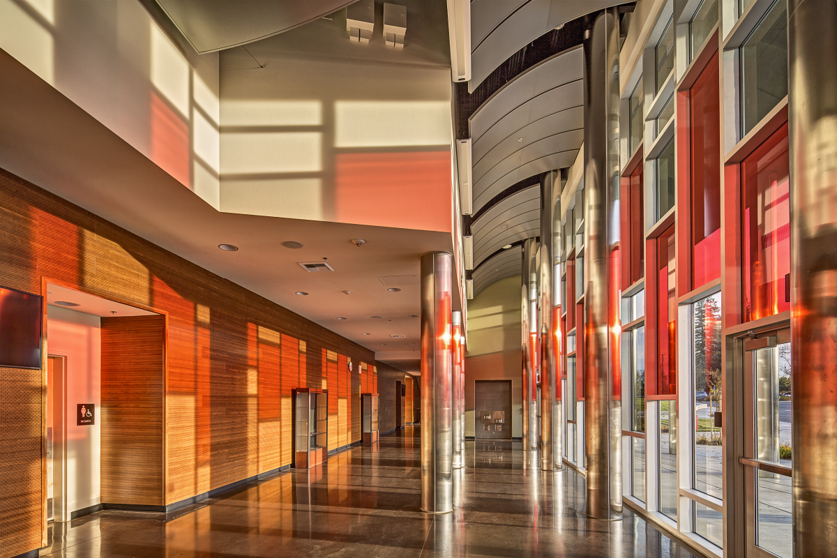 a long hallway with several rows of red cabinets