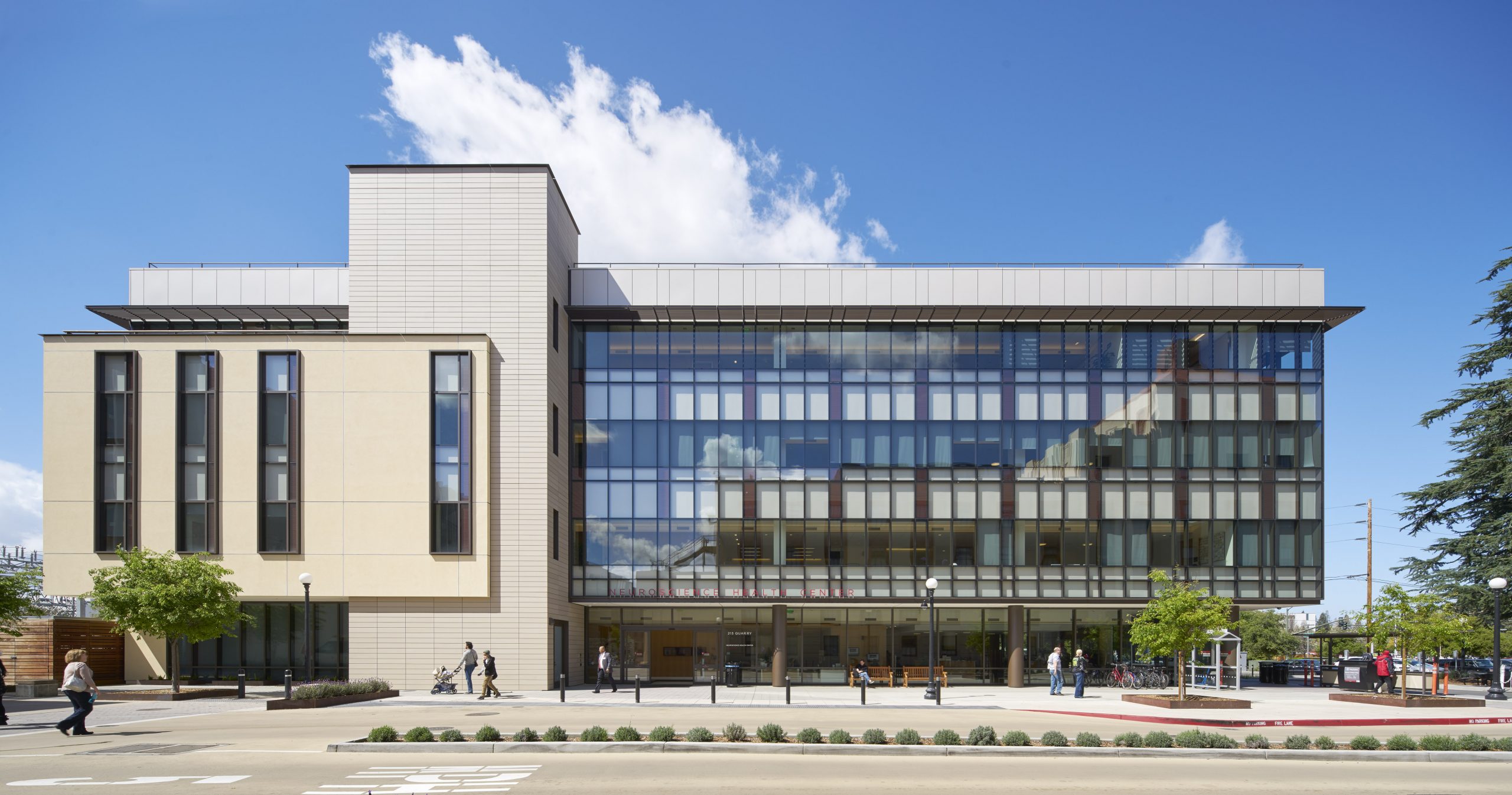 a large building with a lot of windows and a few people walking