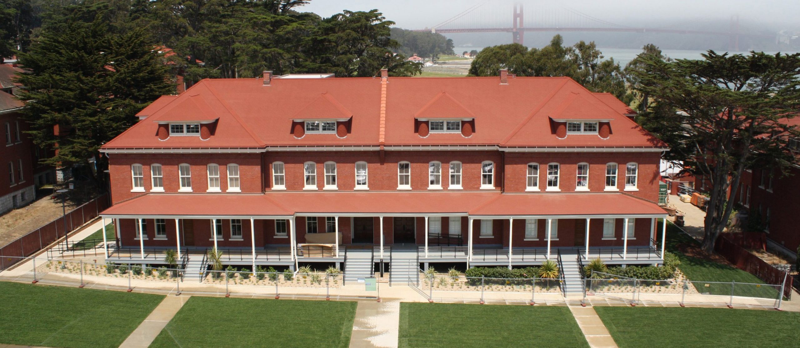 a large red building with a green lawn in front of it