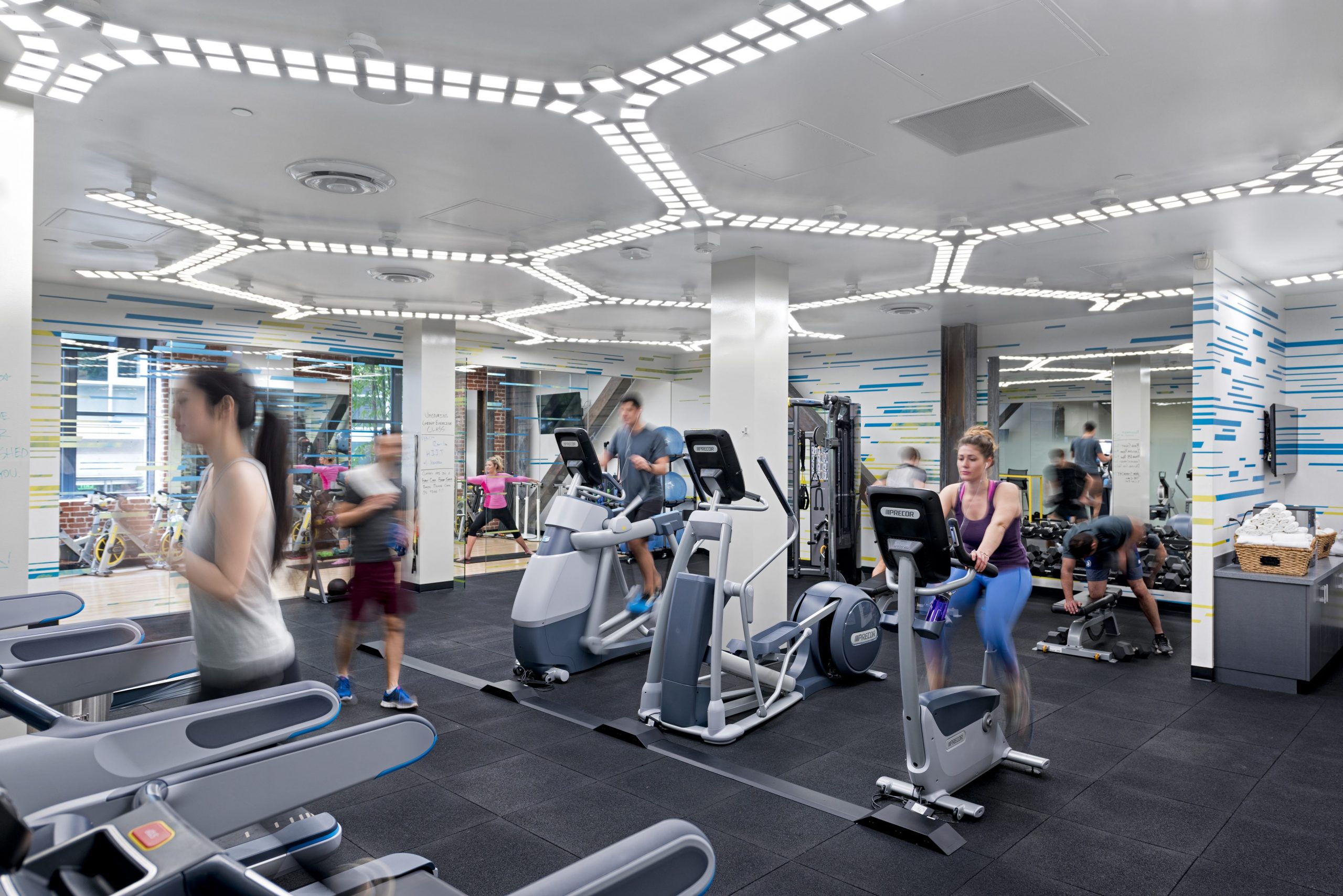 people in a room with treadmills